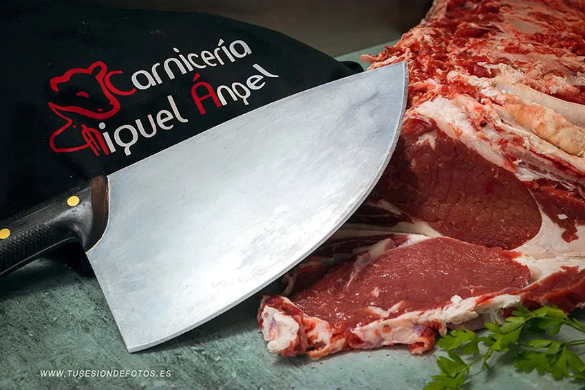 fotografía de un bodegón con un entrecot, una botella de vino y un cuchillo de carnicero